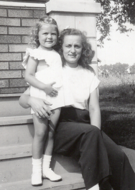 A person and a child sitting on a porch